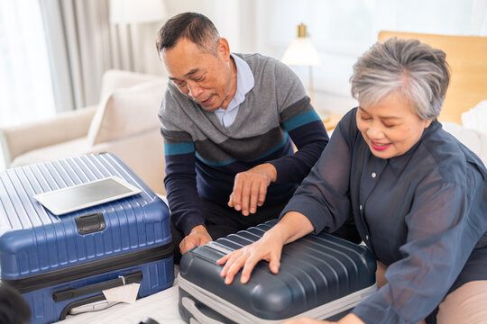 Senior couple packing suitcase for travel, asian elderly preparing for vacation, grandparents organizing luggage, retirement travel planning enjoying trip preparation packing essentials for holiday - Powered by Adobe