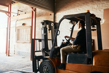 Employee, man and driving forklift at workshop for woodwork, furniture and wood. Male person, small...