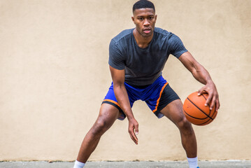 African american basketball player training outdoors - Sportive man playing basketball on a outdoor court in New York  City © oneinchpunch
