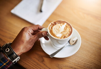 Coffee shop, above and hands of person with cup for drink, caffeine beverage and cappuccino. Latte foam, top view and customer with mug in restaurant, cafeteria and diner for breakfast service