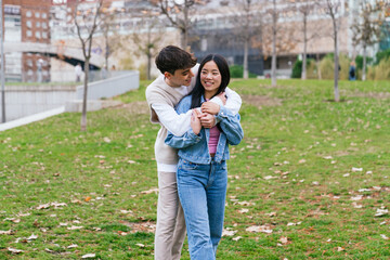Fototapeta premium Young multiethnic couple hugging in a park