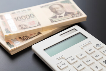 黒背景に一万円の札束と電卓