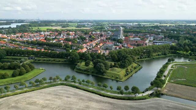 around brielle&rsquo;s 17th century church surrounding fortifications roads bridges river flows near historic site circling aerial shot netherlands fortified town view 