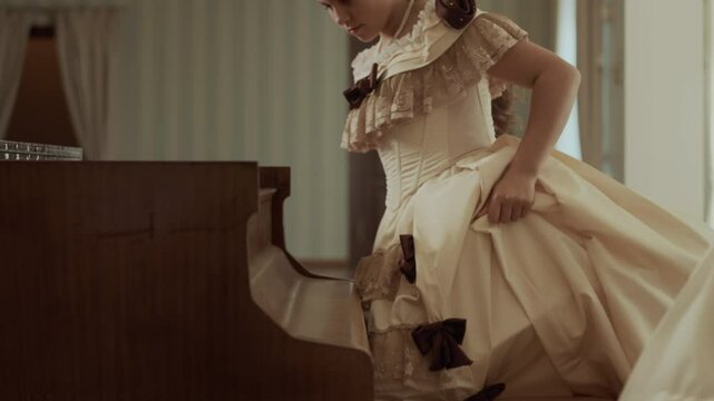 Two young Victorian women in elegant dresses walking towards vintage wooden piano, opening it and starting music lesson in wealthy drawing room with classical decor