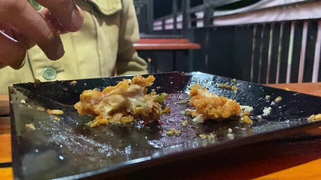 Eating "Ayam Geprek" Indonesian Traditional Food with chili Suce at the restaurant