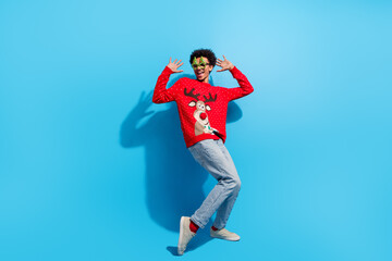 Obraz premium Full body photo of attractive young man excited dancing dressed red christmas sweater theme party on blue color background
