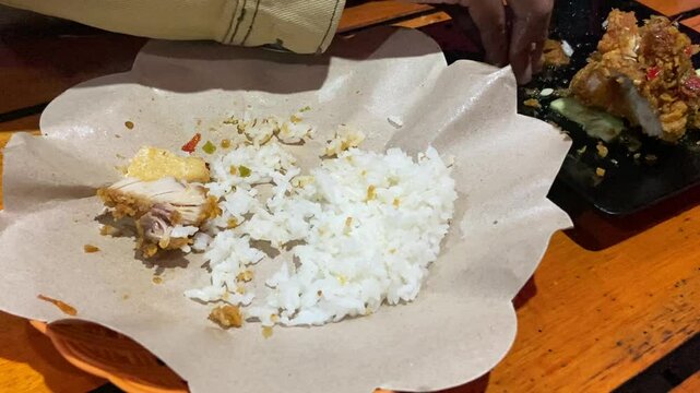 Eating "Ayam Geprek" Indonesian Traditional Food with chili Suce at the restaurant