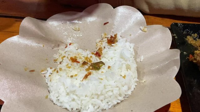 Eating "Ayam Geprek" Indonesian Traditional Food with chili Suce at the restaurant