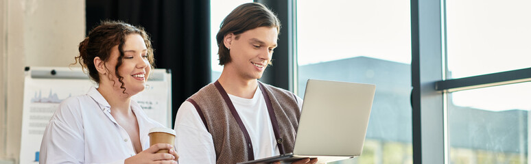 A plus size woman and her male friend share a cheerful moment while using a laptop together.