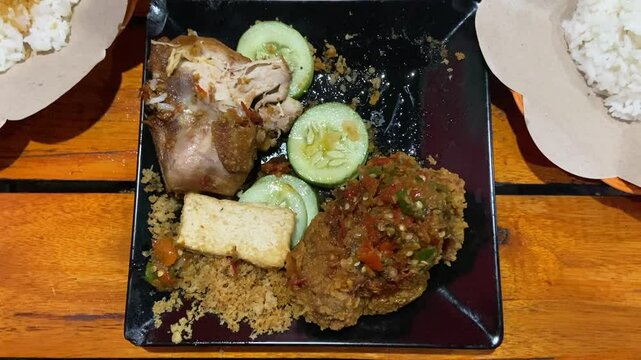 Eating "Ayam Geprek" Indonesian Traditional Food with chili Suce at the restaurant