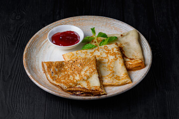 breakfast, pancakes with jam. on a black wooden background