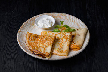 breakfast, pancakes with sour cream. on a black wooden background