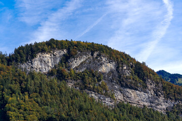Scenic mountain panorama with autumn color woodland in the Swiss Alps at Hasli Valley on a sunny autumn day. Photo taken October 17th, 2023, Meiringen, Canton Bern, Switzerland.