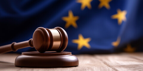 The European Union flag fills the background, with a wooden gavel in sharp focus in the foreground, representing the legal and judicial systems that uphold EU regulations.
