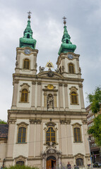 Fototapeta premium Baroque Twin Clock Towered Saint Anna Church in Buda Along Danube River in Budapest, Hungary.