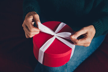 Cropped photo of senior female hands open gift pull ribbon wear christmas clothes enjoy cozy x-mas...