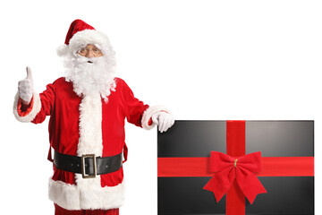 Santa claus gesturing thumbs up and leaning on a tv with red ribbon