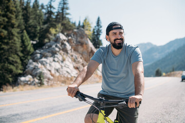 A man on a bicycle on a mountain road on a sunny day.