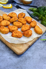 Crispy  deep fried   chicken  popcorn  nuggets and french fries . Breaded  with Cornflakes chicken  Breast fillets  with chilly peppers and fresh   basil on wooden rustic background