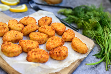 Crispy  deep fried   chicken  popcorn  nuggets and french fries . Breaded  with Cornflakes chicken  Breast fillets  with chilly peppers and fresh   basil on wooden rustic background