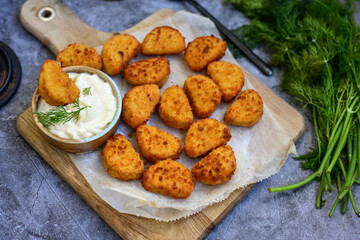 Crispy  deep fried   chicken  popcorn  nuggets and french fries . Breaded  with Cornflakes chicken  Breast fillets  with chilly peppers and fresh   basil on wooden rustic background