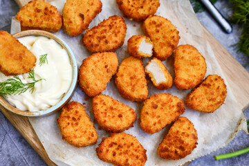 Crispy  deep fried   chicken  popcorn  nuggets and french fries . Breaded  with Cornflakes chicken  Breast fillets  with chilly peppers and fresh   basil on wooden rustic background