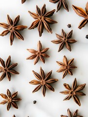 Fototapeta premium Star anise arranged on white surface.
