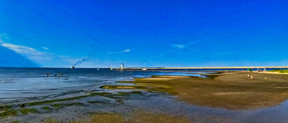 A vast sandy sea beach. Sunset over the sea. Beautiful sunny weather over the sea on a summer afternoon.