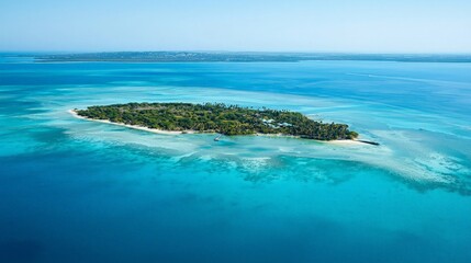 An aerial view of a small tropical island with lush vegetation and a white sandy beach surrounded by crystal clear turquoise waters.