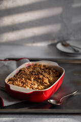 Crumble, Crisp or Cobbler with nectarines, peaches and rolled oats in casserole dish on a metal tray. American cuisine. Easy dessert.