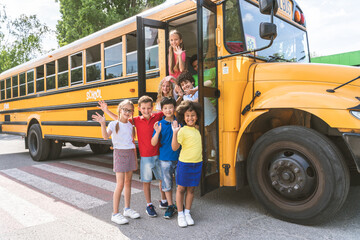 Group of young students attending primary school on a yellow school bus