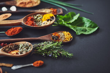 Kitchen, curry and spices with spoon, cooking or ingredients for flavor with culinary art. Seeds, leaves and above utensils on counter for meal prep, cinnamon and rosemary for food at restaurant