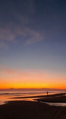 Silhouette of a man at sunset by the sea. wonderful colorful sunset on a calm sea with shore