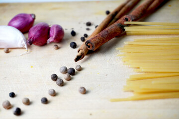 raw spaghetti and herbs and spices on wooden table