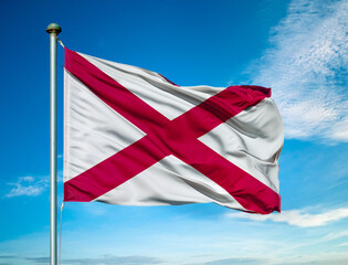 Alabama state flag waving in the wind against a blue sky background