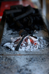 the dying fire, burning firewood, Orange smoldering coals and low flame in barbecue, Burning charcoal to burn satay or meat,
