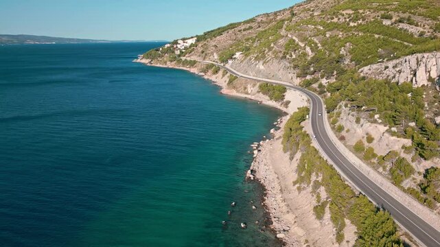 Winding road between the sea and the mountains at sunny morning time on the Adriatic coast near Omis, Dalmatia, Croatia