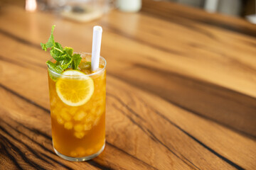 Close-up piña colada tea cocktail with peach balls, orange or lemon slice and mint, non-alcoholic cocktail, refreshing and healthy drink, free background to write, copy space
