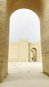 Walking through archs in Babylon great walls restored by Saddam Houssein. Babylon, Iraq. Vertical