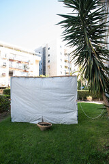 Jewish festival of Sukkot in Israel. Traditional sukkah with handmade decorations near the building on the street. 
