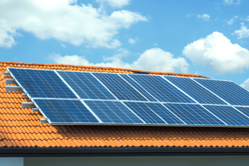 Solar panels on tiled roof against blue sky for sustainable energy solutions
