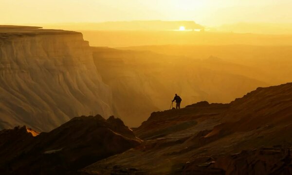 Steadicam shot with warm, golden hour hues: The camera starts by following a geologist examining a subduction zone. It then moves smoothly across the zone with warm, golden hour hues enhancing the sce