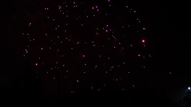 Silver blue green sparks scattering fireworks on the black night sky. General plan