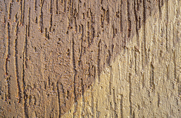 Abstract texture of decorative plaster. Deep vertical grooves on the surface. An inclined line separates two parts of different shades. Copy space.