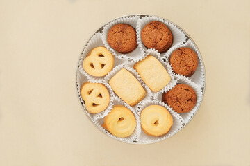 Cookies set in a metal box. Sweet dessert for holiday on beige background. Variety of biscuit. Top view.