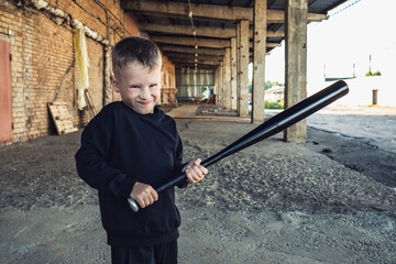 Little boy in black with a baseball bat.
