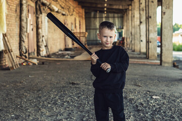 Little boy in black with a baseball bat.
