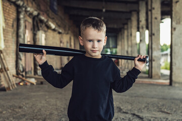 Little boy in black with a baseball bat.