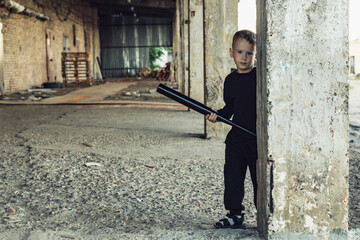 Little boy in black with a baseball bat.