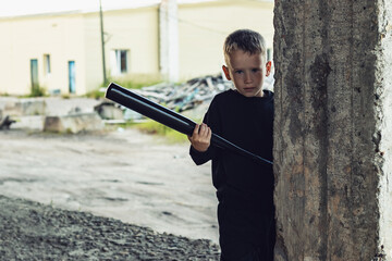 Little boy in black with a baseball bat.